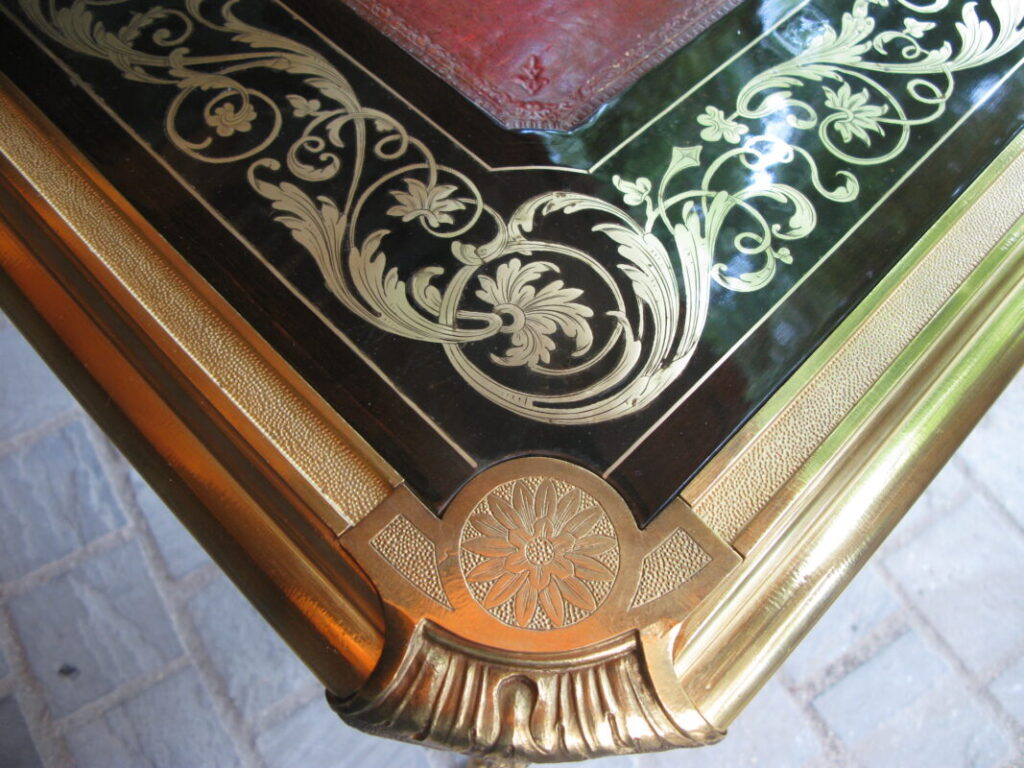 Détail de marqueterie Boulle techniques ancestrales avec incrustations de laiton sur fond d’ébène et encadrement en bronze doré.