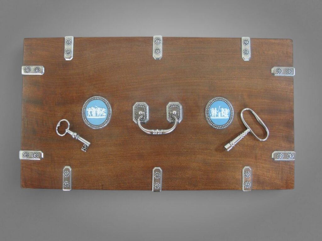 Vue du couvercle d’un meuble à mécanisme sur mesure présentant ses éléments métalliques, poignées et serrures travaillées à la main