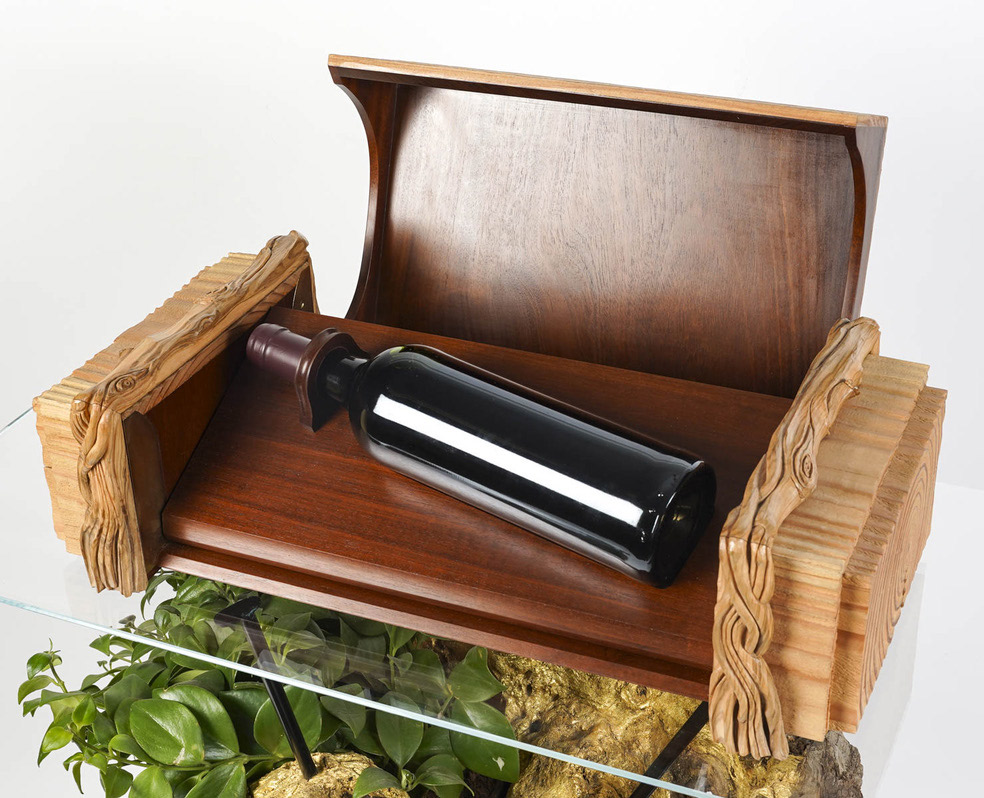 Coffret en bois sculpté conçu pour une bouteille de vin, exemple d’ébénisterie durable.