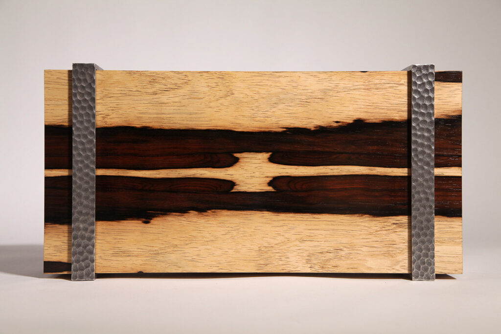 Coffret en bois clair et foncé avec incrustations métalliques, issu d’une ébénisterie durable.