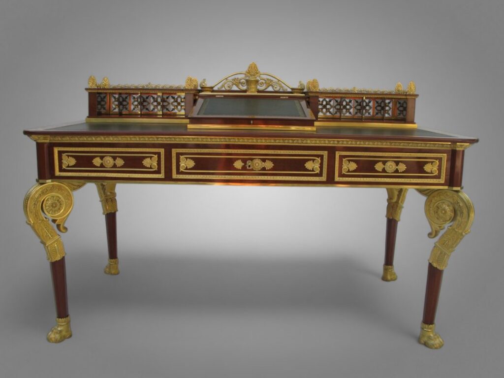 Bureau d’époque Empire orné de bronzes et incrustations raffinées, symbole du meuble à secrets sur-mesure alliant artisanat, précision et esthétique intemporelle.
